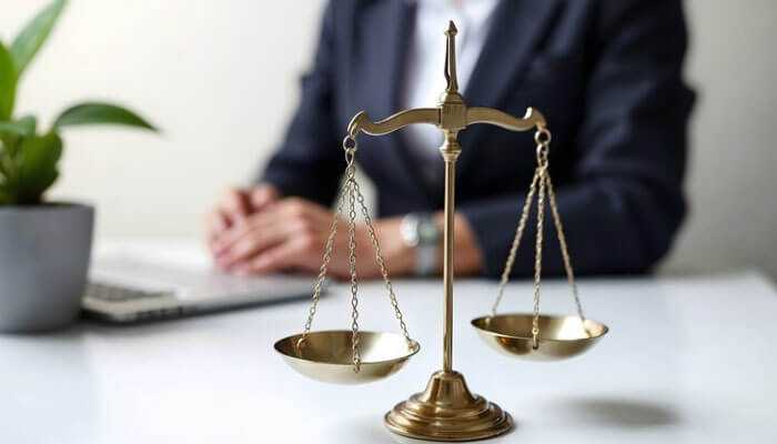 Pure and modified comparative negligence - tycoonstory | tycoonstory media Golden balance scale in front of a professional, symbolizing justice and comparative negligence in slip and fall cases.