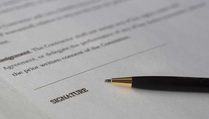 Small businesses grow - tycoonstory | tycoonstory media A close-up of a contract with a pen resting near the signature line, symbolizing the signing process related to commercial real estate loans.