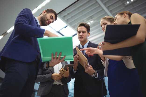 Staying competitive in a fast-moving world - tycoonstory | tycoonstory media Professionals reviewing files and strategies together, highlighting collaboration and growth within small and medium enterprises.