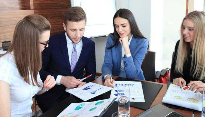 Strong financial acumen is essential - tycoonstory | tycoonstory media Hiring a coo qualities – a professional business team analyzing reports and discussing strategies in a corporate meeting.