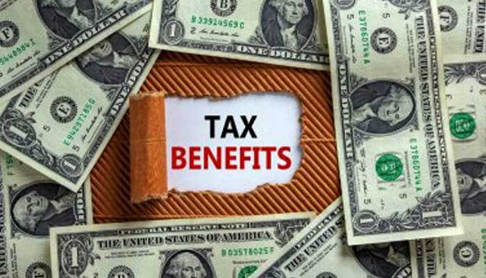 Tax benefits - tycoonstory | tycoonstory media A torn paper revealing the text'Tax Benefits' surrounded by U.S. dollar bills, symbolizing the financial advantages of tax-saving strategies.