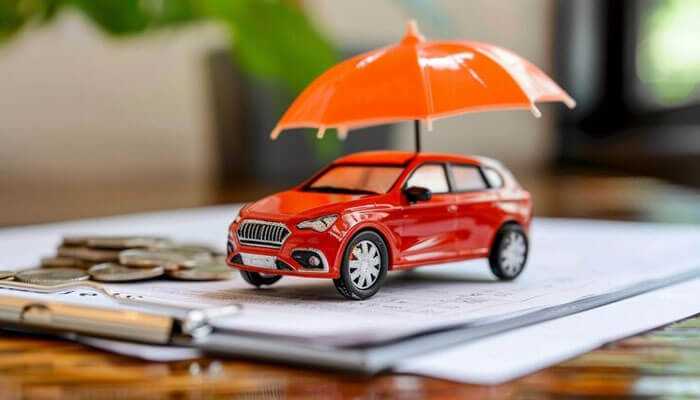 What are the insurance costs - tycoonstory | tycoonstory media A miniature red car under an orange umbrella placed on documents symbolizing car insurance and financial protection