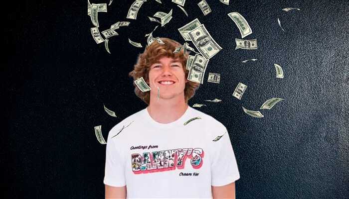 What is danny duncan net worth - tycoonstory | tycoonstory media Danny duncan smiling while wearing a branded t-shirt, with dollar bills falling around him against a dark background, symbolizing wealth and success