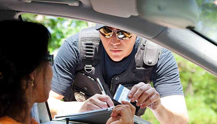 Consequences of traffic violations - tycoonstory | tycoonstory media Officer handing a citation to a driver, representing types of traffic violations like failure to carry proper documentation or traffic law infractions