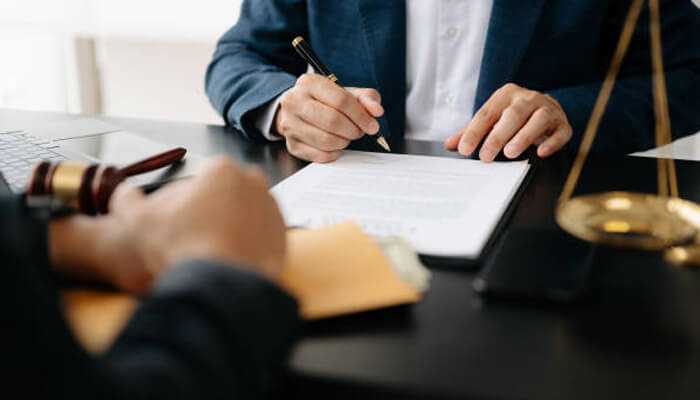 Evaluate communication skills - tycoonstory | tycoonstory media Lawyer reviewing legal documents with a client for a work accident claim case.