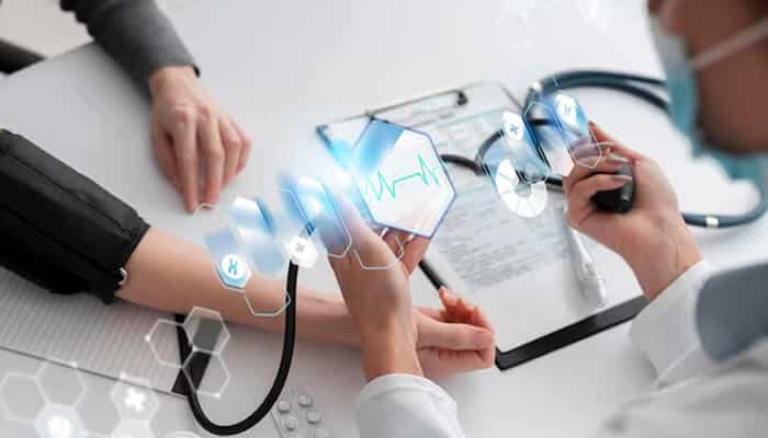 Health insurance - tycoonstory | tycoonstory media Doctor using a stethoscope on a patient's arm while displaying digital health data, symbolizing the integration of technology in healthcare.