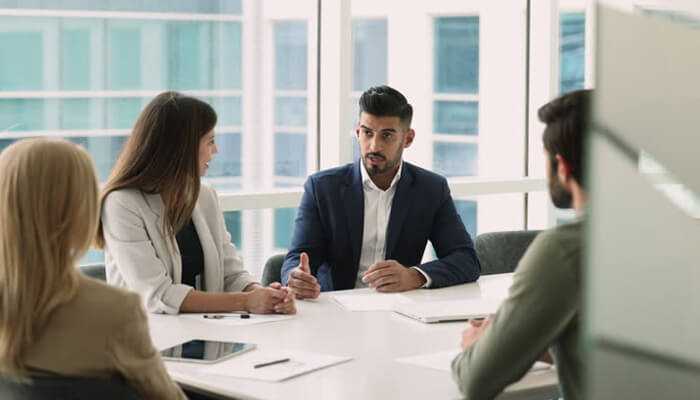 Human element in investment decision-making - tycoonstory | tycoonstory media Business professionals discussing investment plans and portfolio decisions in an active asset management meeting.