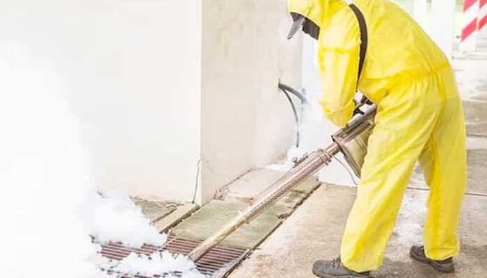 Iu2 | tycoonstory media Technician in a hazmat suit using industrial equipment for deep sanitation during basement damage cleanup in a flooded area.