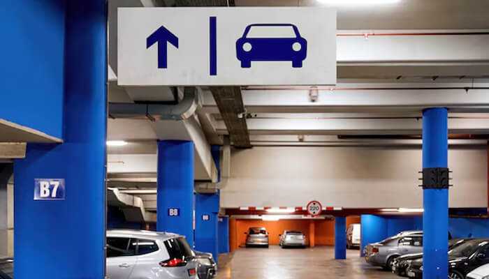 Parking solutions - tycoonstory | tycoonstory media A modern parking garage showcasing parking lot innovations with clear signage, well-lit spaces, and organized parking.