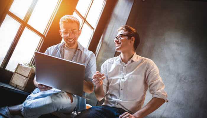 Seo company - tycoonstory | tycoonstory media Two digital marketing professionals discussing strategies while reviewing data on a laptop, showcasing teamwork at the best seo company in australia.