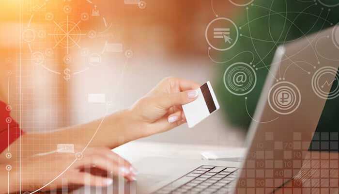 Streamlining operations with digital integration - tycoonstory | tycoonstory media A person holding a credit card in one hand while typing on a laptop with the other, suggesting an online payment or shopping activity. Digital financial icons and graphics overlay the image.
