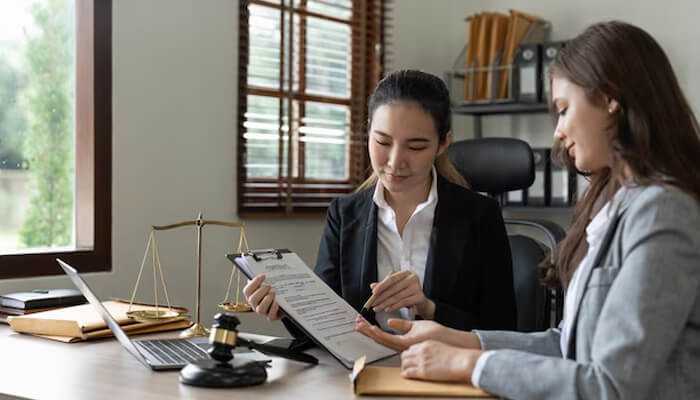 Understanding temporary hiring - tycoonstory | tycoonstory media Two contract legal assistants reviewing documents in a professional office setting, ensuring accuracy and compliance with legal requirements.