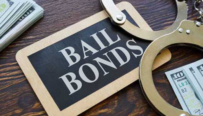 Understanding the process of bail bonds - tycoonstory | tycoonstory media Emergency bail services - a wooden desk with a'Bail Bonds' sign, handcuffs, and stacks of cash, symbolizing quick and reliable legal assistance for urgent bail needs.