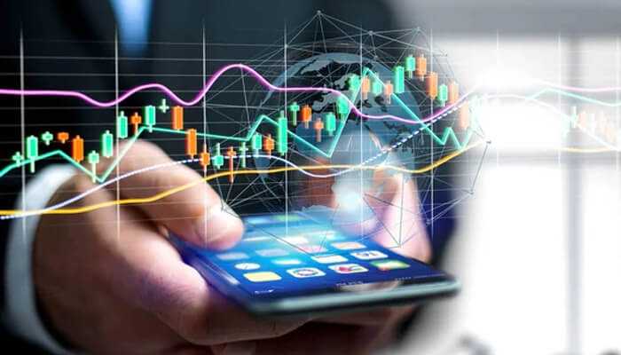 User experience - tycoonstory | tycoonstory media A person using a smartphone for online trading, with financial charts, graphs, and a global network overlay, representing finzilo's trading platform and market analysis tools.