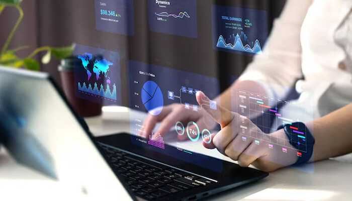 What exactly is an erp system - tycoonstory | tycoonstory media Person analyzing business data on a laptop with futuristic digital graphs and charts, representing the power of erp systems for real-time decision-making and efficiency.
