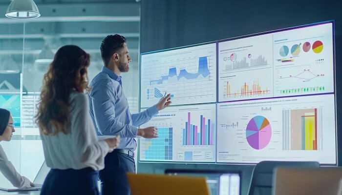 An approach to financial stabilityan approach to financial stability | tycoonstory media A team reviewing financial data and charts on large screens, illustrating a structured approach to financial planning and analysis.