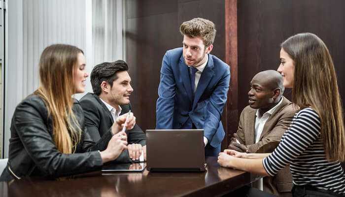 Build a core community before you scale | tycoonstory media A diverse group of professionals collaborating in a meeting, discussing strategies and ideas for an advocacy group, working together to drive social change and impact.