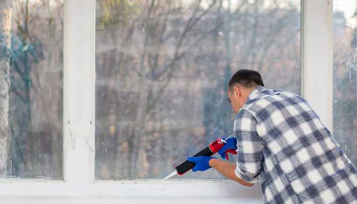 Cost implications of repair versus replacement | tycoonstory media A man points to a broken window, highlighting the need for glass damage repair and replacement services.