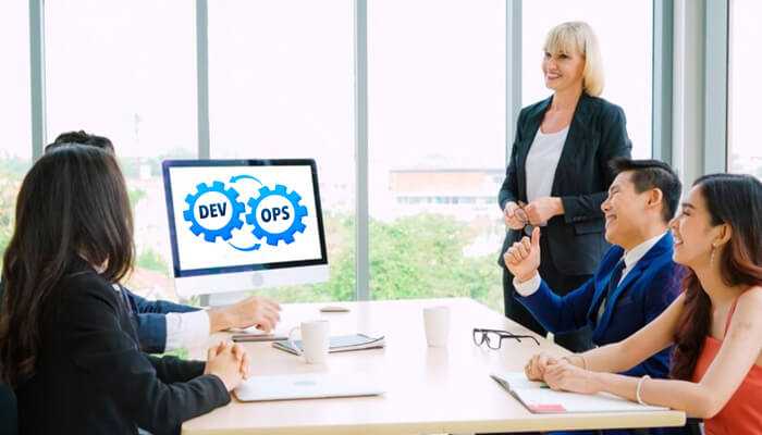 Dev | tycoonstory media Business team collaborating on devops architecture strategy during a meeting, with devops workflow displayed on a computer screen.