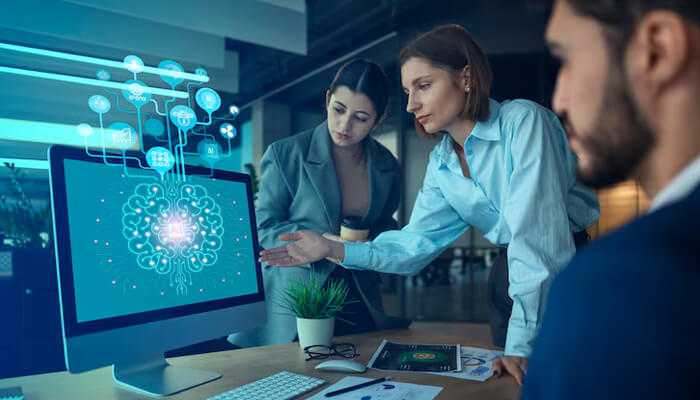 Embedded intelligence | tycoonstory media Business team exploring edge ai solutions on a computer screen, illustrating the power of artificial intelligence in decision-making.