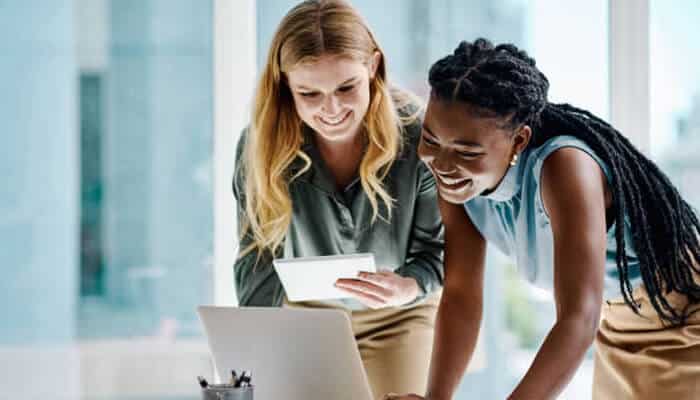 Following your passion | tycoonstory media Two women collaborate on a laptop, exploring options to launch small business together.