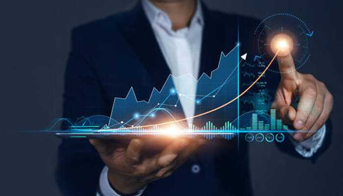 Industry trends and sector-specific factors | tycoonstory media Business professional interacting with a virtual financial graph showing upward trends, representing nifty stock market analysis and investment growth.
