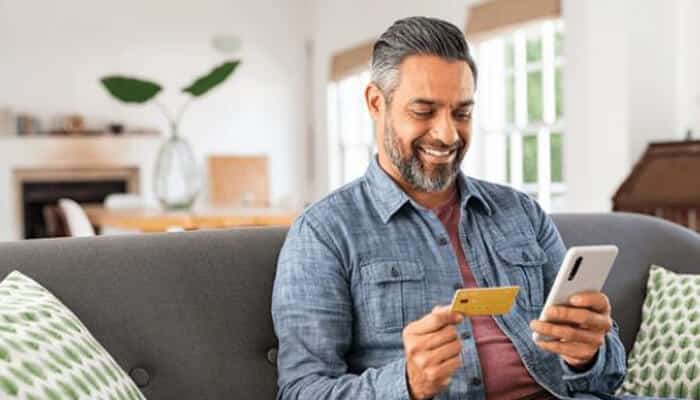 Prepaid | tycoonstory media Person using a prepaid card for online payment with a smartphone.