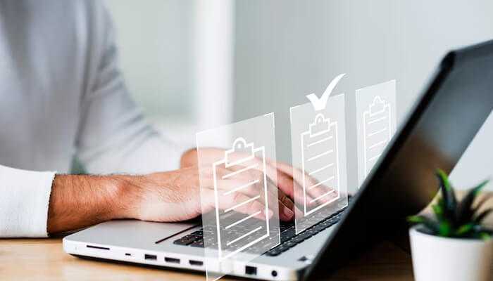 Remote access and flexible workflow | tycoonstory media Person using a laptop with digital checklists representing document processing, symbolizing the efficiency and remote accessibility of online fax services.