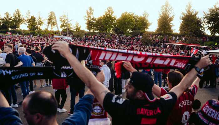 Small shops big wins | tycoonstory media Fans gather outside a stadium, showing how sports boost local economies through community spending and local business support.
