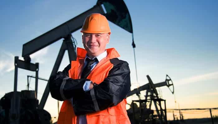 Wtr | tycoonstory media Oil and gas jobs: industry professional standing confidently at an oil production site.