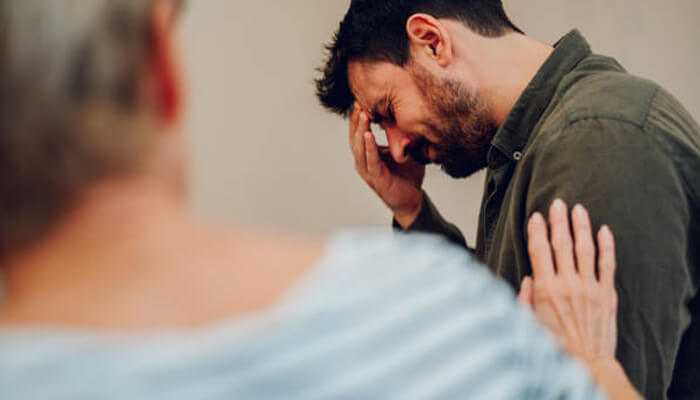Benefits of compassionate alcohol rehab | tycoonstory media A distressed man receiving emotional support during a counseling session, highlighting the importance of compassionate care in alcoholic rehab.