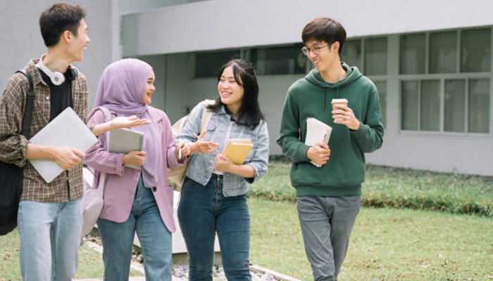 Destinations academy | tycoonstory media Four students walking and talking on campus, representing beautiful destinations academy in dubai.