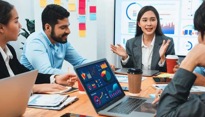 Digital marketing agency in birmingham | tycoonstory media Eam meeting at a digital marketing agency in birmingham, with professionals discussing analytics and strategy around a table filled with laptops and performance charts.