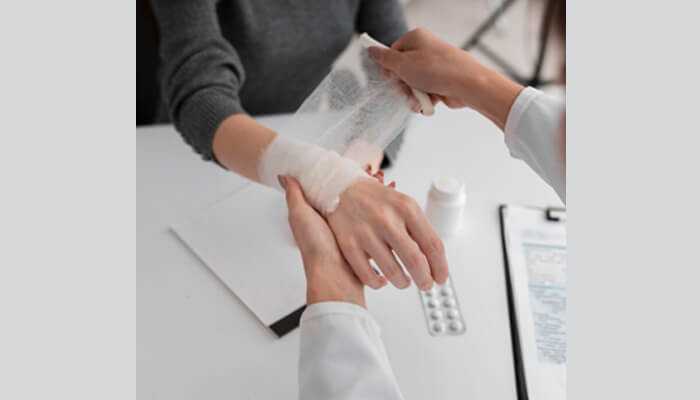 Dont get emotional about the case | tycoonstory media Medical professional wrapping a bandage around a wrist during treatment for personal injury cases, showing careful medical care.