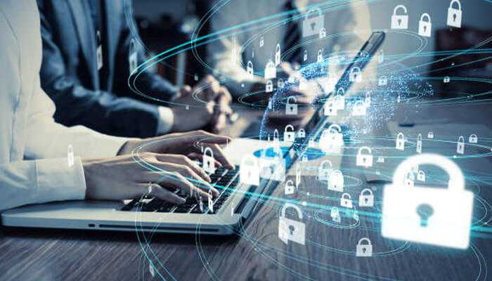 Encrypted data transmission | tycoonstory media Business professionals using laptop and smartphone with digital locks overlay, illustrating securing iot devices and data protection in a connected environment.