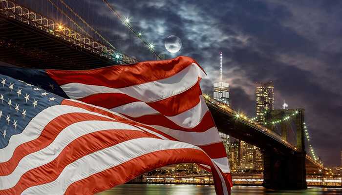 Ensuring internal systems reflect new contract details | tycoonstory media American flag waving in front of a city skyline at night, symbolizing gsa contracts and federal opportunities in the united states.