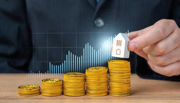Ia | tycoonstory media Stacks of gold coins increasing in height with a hand placing a house model on top, representing financial growth and investment during the stages of wealth.