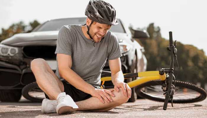 Injury | tycoonstory media A cyclist injured after an accident, highlighting the importance of sports injury prevention and safety measures like wearing protective gear during sports.