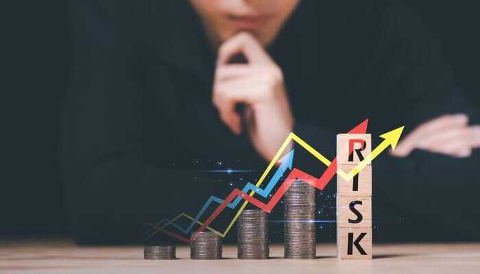 Mitigating financial risks for investors | tycoonstory media A thoughtful investor analyzing stacked coins and upward graphs, symbolizing financial growth and increasing risk levels, highlighting the importance of blockchain audits in managing investment risks.