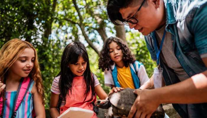 Outdoor exploration and fun | tycoonstory media Children engaging in hands-on learning with a turtle during a summer academic camp outdoor exploration activity.