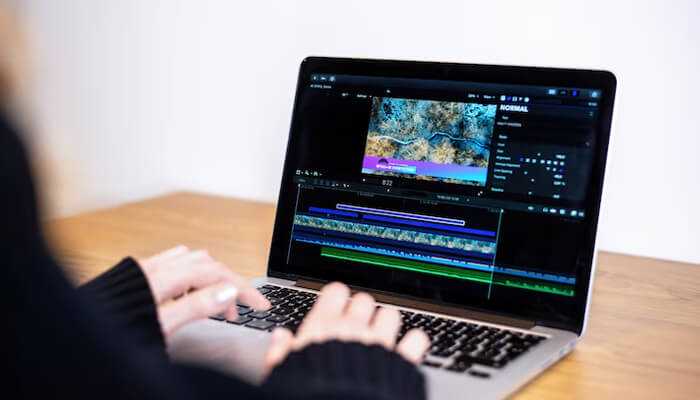 Preserving content integrity | tycoonstory media A person editing a video timeline on a laptop, showcasing professional video watermarking techniques to preserve content integrity and prevent unauthorized use.