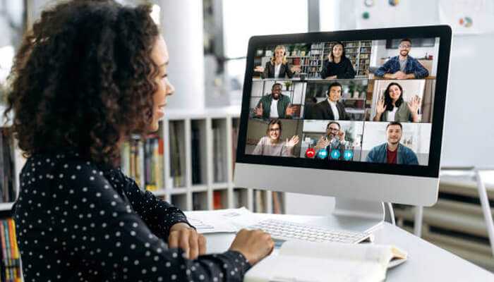 The growth of video conferencing | tycoonstory media A woman participating in a video conferencing call using communication technology with multiple people on screen, showcasing remote collaboration and virtual communication.