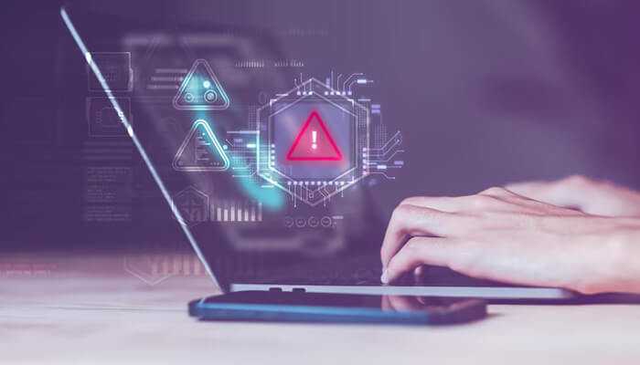 Understanding where risks begin | tycoonstory media Close-up of hands typing on a laptop with red warning and alert symbols on the screen, highlighting cyber risk and data security challenges faced by entrepreneurs.