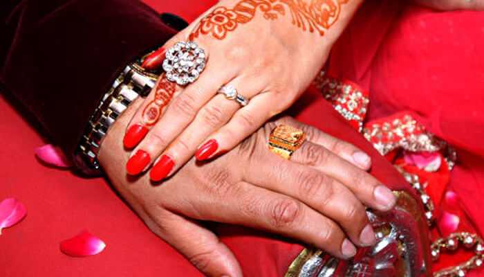 Why dallas leads in custom ring design | tycoonstory media Custom engagement rings in dallas worn by a couple, with the bride’s hand decorated in traditional henna and bright red manicure.