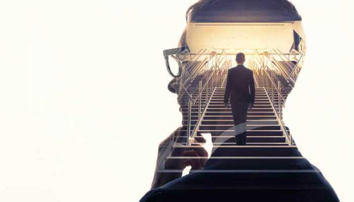 Build discipline before expecting momentum | tycoonstory media Double exposure image of carlos alexandre rozwadowski’s silhouette overlaid with a man walking up a staircase toward a bright light, symbolizing progress.