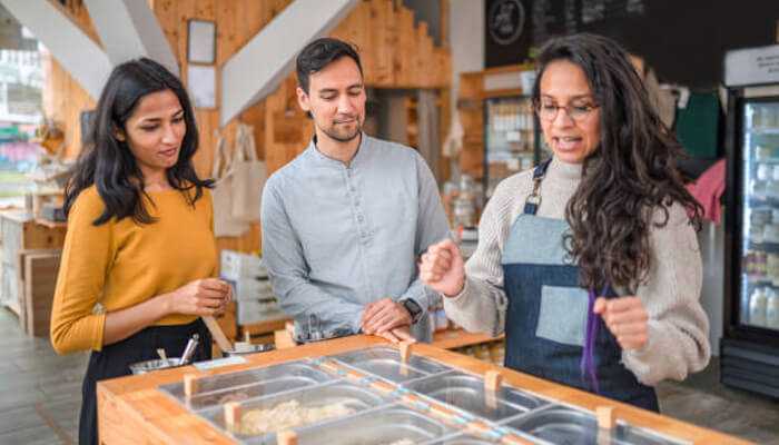 Consumers want to know where their food comes from | tycoonstory media Food manufacturing process where a team is discussing the production in a food store, showcasing the art of food preparation and distribution.