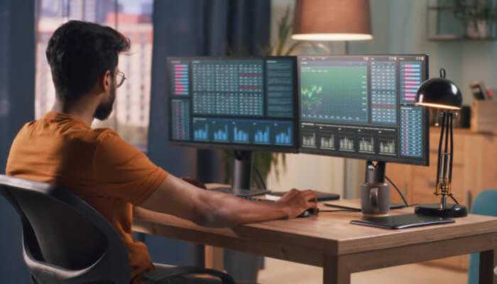 Dow jones futures performance - tycoonstory | tycoonstory media A trader using multiple monitors to track dow jones futures, displaying real-time market data, charts, and financial indicators for informed trading.