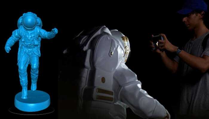 Einstar vega strike for elevating your ar workflow | tycoonstory media A detailed astronaut figure being 3d scanned by a person, showcasing how physical objects are digitized for use in augmented reality applications.