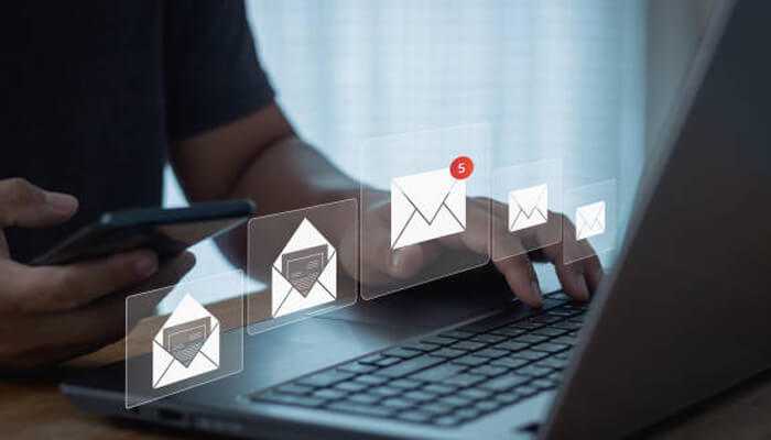 Improve email and sms campaigns | tycoonstory media A user managing multiple email notifications on a laptop and smartphone, showcasing streamlined communication through cdp solutions.