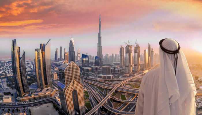Key features of dubais e-government system | tycoonstory media Traditional emirati man overlooking modern dubai cityscape at sunset, representing the blend of heritage and digital transformation through egsh.